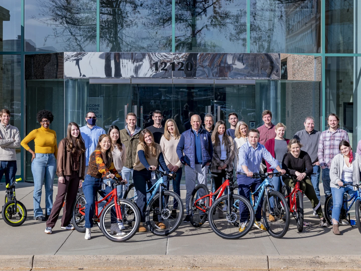 group of Brightspot employees at front of Brightspot's Reston office with bicycles they assembled as part of a bike donation event for charity