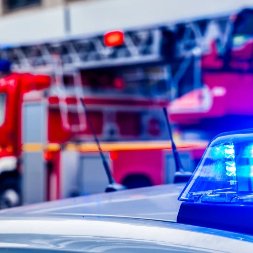 blue flash light of police car against red fire truck