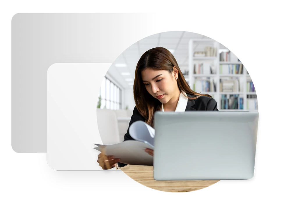 graphic depicting female professional looking at paperwork in front of a laptop screen