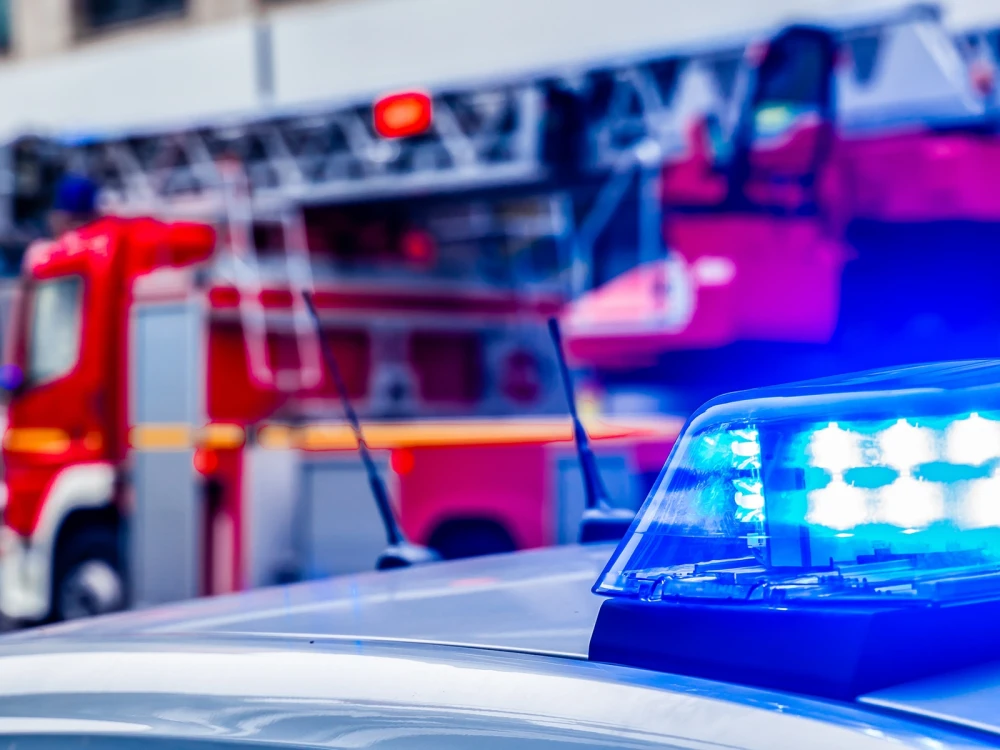 blue flash light of police car against red fire truck